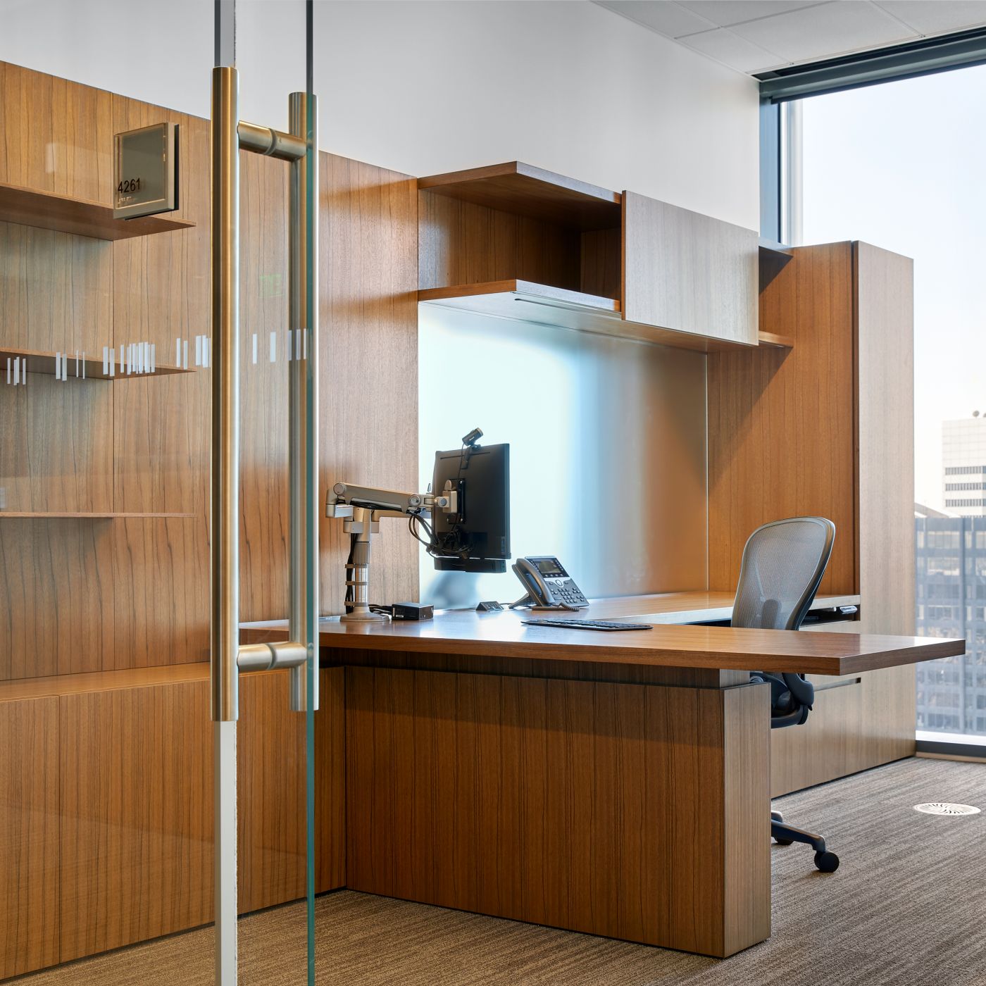 Universal-sized offices feature NEW MILLENNIA with Paldao veneers, etched mirror glass, and adjustable-height worksurfaces.
